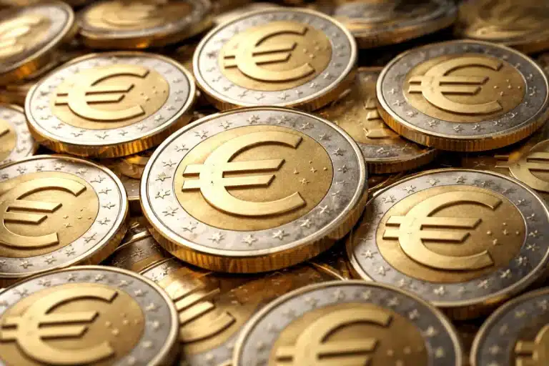 Plusieurs pièces en euros empilées et superposées, avec le symbole € visible au centre de chaque pièce.
